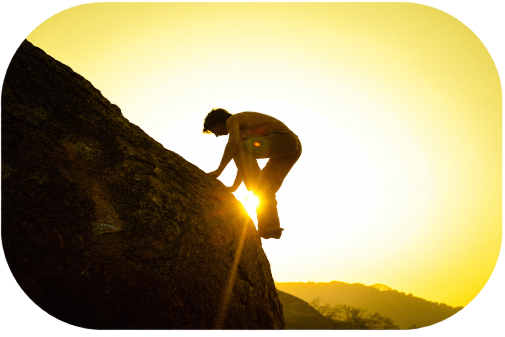 Persona escalando una montaña al atardecer, representando un proceso de superación y desarrollo personal – Clínica Víctor Navalón